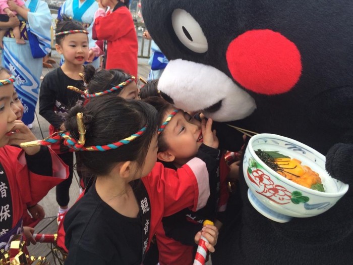 Kumamon hanging out with a fan while eating sea urchin